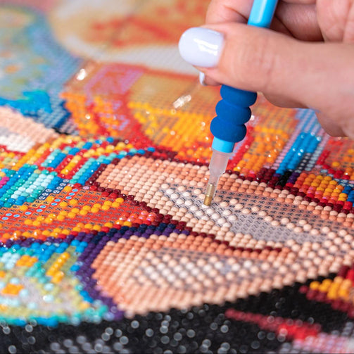 a person filling in an arm on a diamond painting of a person