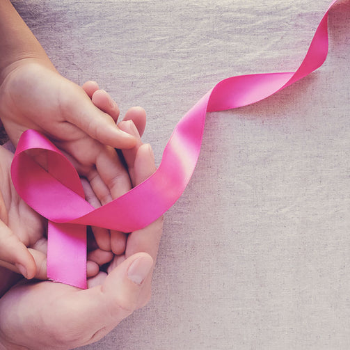 hands holding pink ribbons