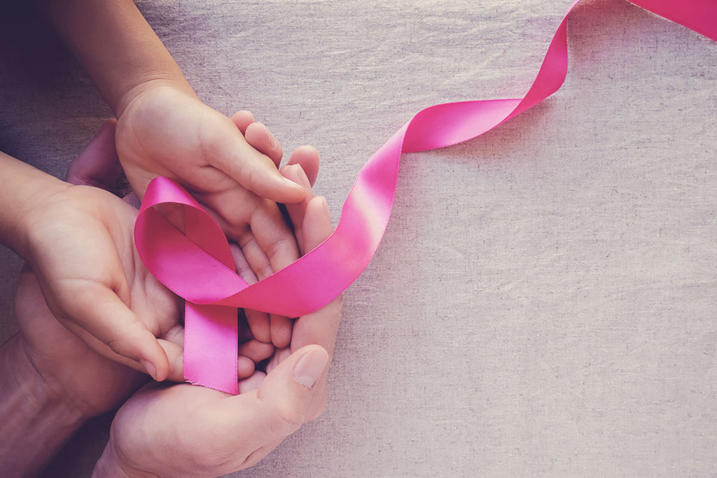 hands holding pink ribbons