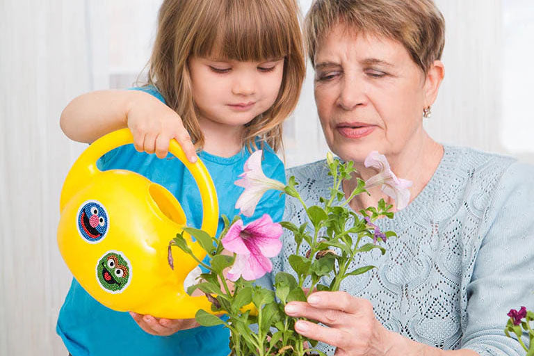 mother daughter watering flowers