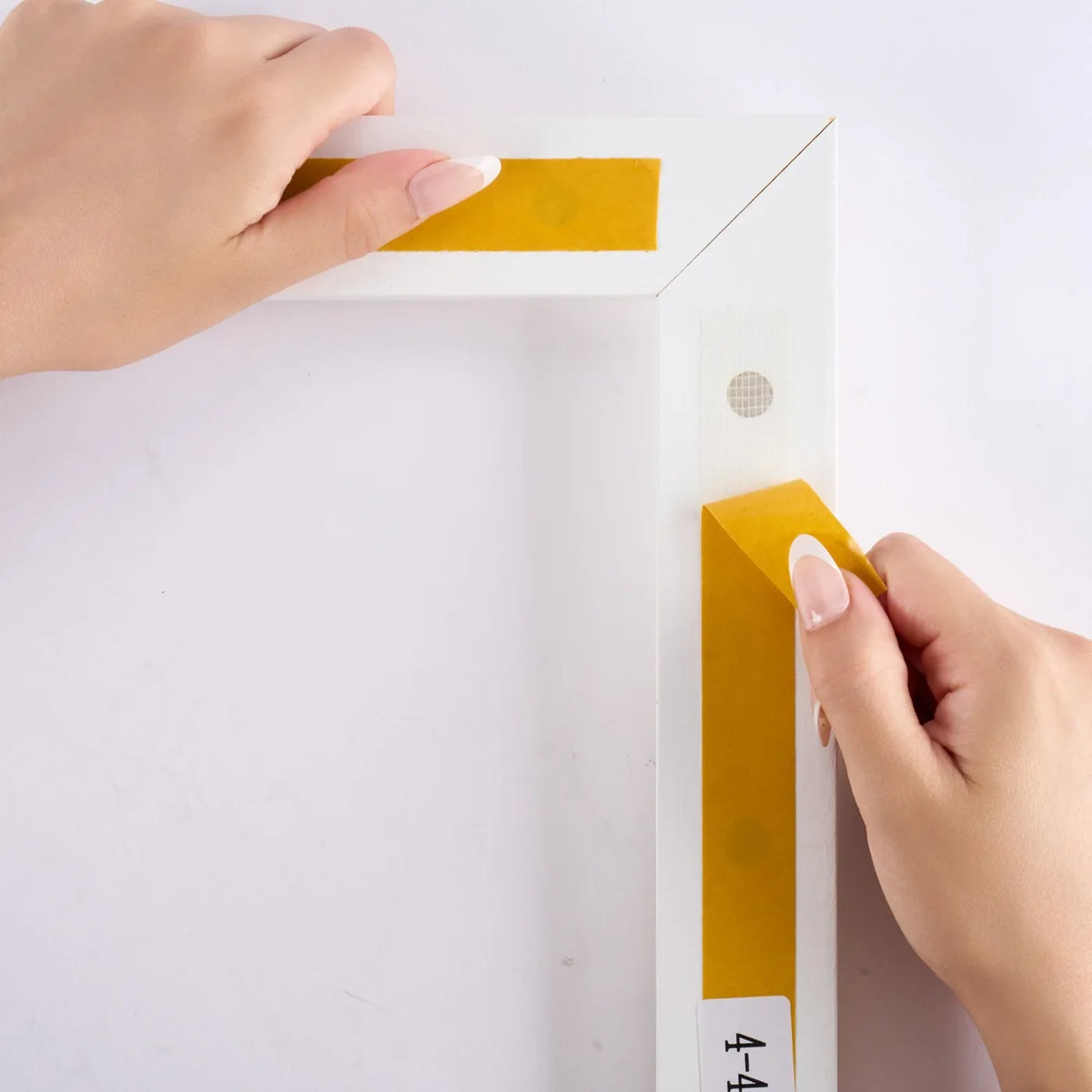 Peeling the liner from the InstaFrame adhesive-backed mounting section